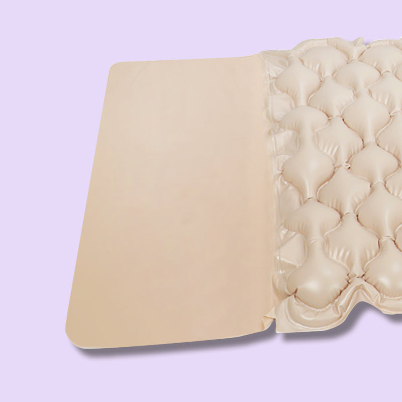 Beige quilted mattress topper on a light purple background