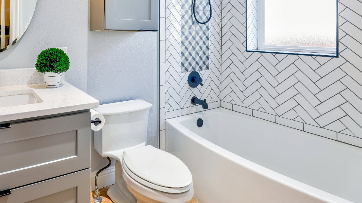 Modern bathroom with sink, mirror, toilet, and bathtub.